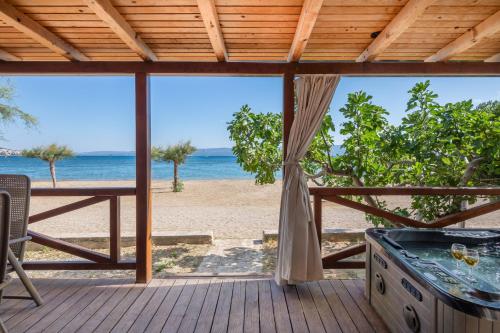 a deck with a hot tub and a view of the beach at Camping Almissa in Omiš