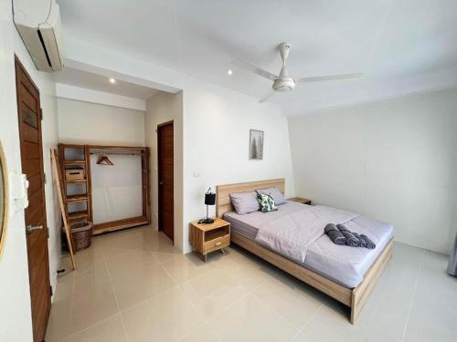 a bedroom with a bed and a ceiling fan at Chill Lay Resort Donsak in Don Sak