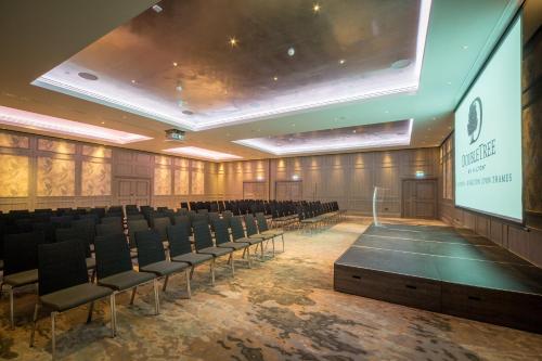 a lecture hall with chairs and a projection screen at DoubleTree by Hilton London Kingston Upon Thames in Kingston upon Thames