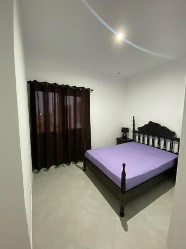 a bedroom with a purple bed in a room at Apartamento Rua do museu dos Náufragos in Sal Rei