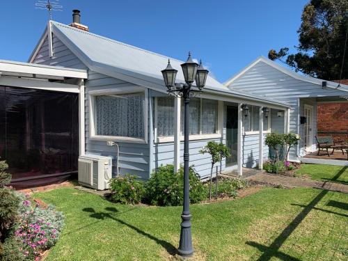 a house with a street light in the yard at That Seaside Cottage - Fully equipped home, 4 Bedrooms on the foreshore in Tooradin