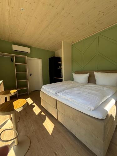 a bedroom with a large bed with a green headboard at La Vista Verde vom La Fattoria in Bad Gandersheim