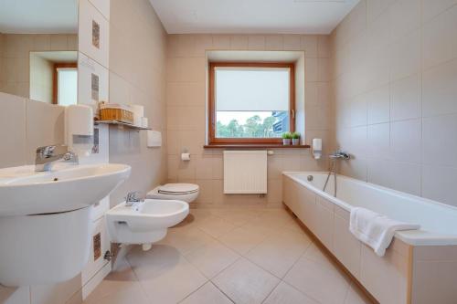 a bathroom with a sink and a toilet and a bath tub at Hotel Aviator in Kamień Śląski