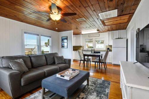 a living room with a couch and a table at Cozy cottage by the Sea -near downtown with patio! in Gulfport