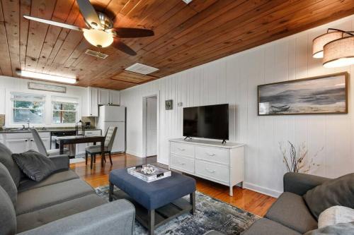 a living room with a couch and a ceiling fan at Cozy cottage by the Sea -near downtown with patio! in Gulfport