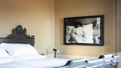 a bedroom with a bed and a mirror on the wall at Vigne di Fagnano 1709 Eco Relais in Santo Stefano Belbo