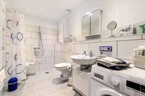 a white bathroom with a sink and a toilet at Traumland in Hollingstedt