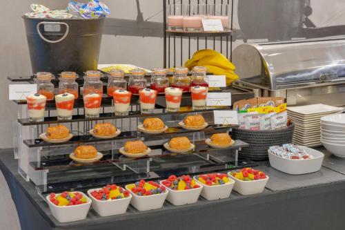 a buffet of food with bowls of fruit and drinks at Hotel Aviator in Kamień Śląski