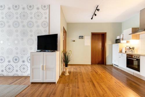 a kitchen with a flat screen tv on a cabinet at Traumland in Hollingstedt