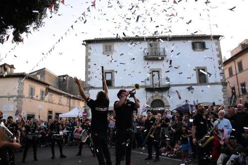 a group of people playing music in a parade at Il Pianerottolo in Manziana