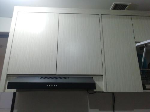 a kitchen with white cabinets and a microwave at Apartemen Transpark Cibubur by Royal Home in Depok