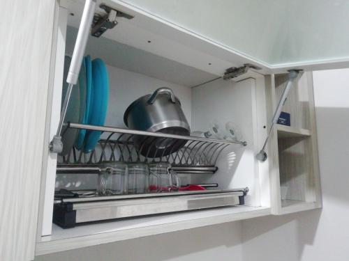 a kitchen cabinet with a pot and utensils at Apartemen Transpark Cibubur by Royal Home in Depok