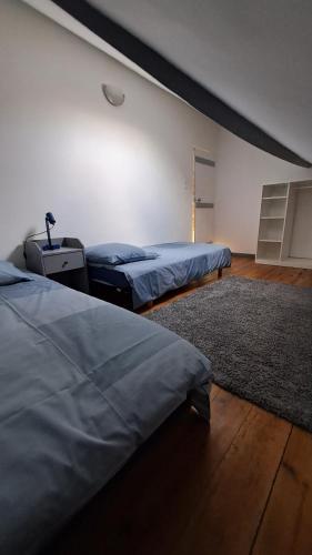 une chambre avec deux lits et un tapis dans l'établissement Maison à la Campagne, à Duclair