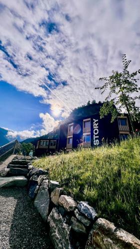 a building on top of a hill with a stone wall at Story Thusis in Thusis