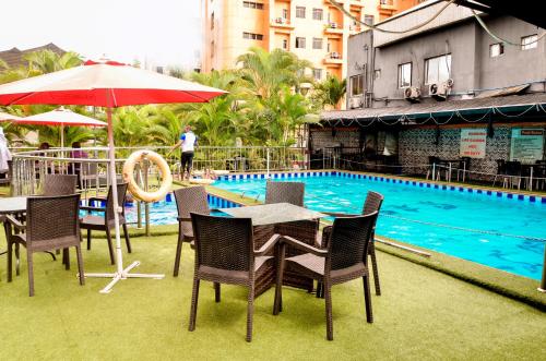 a table and chairs in front of a swimming pool at Danag Apartments in Port Harcourt