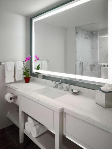 a bathroom with a sink and a large mirror at The Royal Sonesta New Orleans in New Orleans