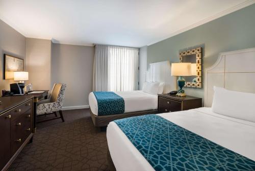 a hotel room with two beds and a desk at The Royal Sonesta New Orleans in New Orleans