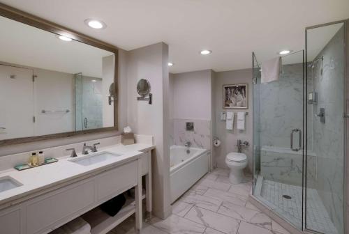 a bathroom with a sink and a shower and a toilet at The Royal Sonesta New Orleans in New Orleans