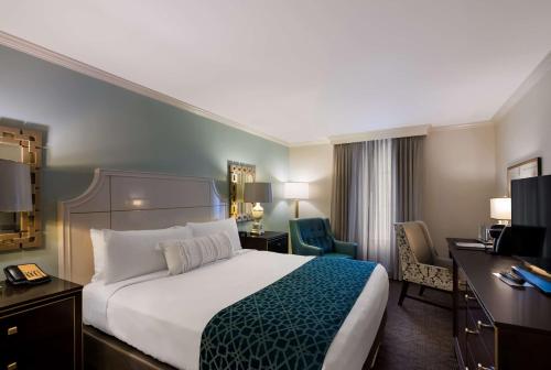 a hotel room with a large bed and a desk at The Royal Sonesta New Orleans in New Orleans