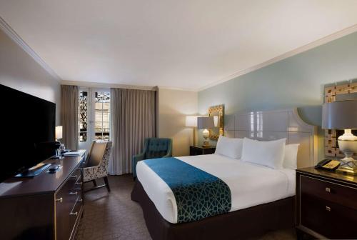 a hotel room with a bed and a desk with a computer at The Royal Sonesta New Orleans in New Orleans