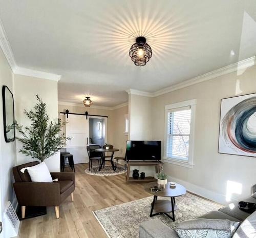 a living room with a couch and a television at Cedar Street Retreat - Heart of Aksarben! in Omaha