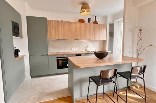 - une cuisine avec un comptoir en bois et 2 chaises dans l'établissement Le Villermont - Liberation Centre Ville, à Nice