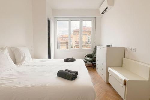 une chambre blanche avec deux lits et une fenêtre dans l'établissement Le Villermont - Liberation Centre Ville, à Nice