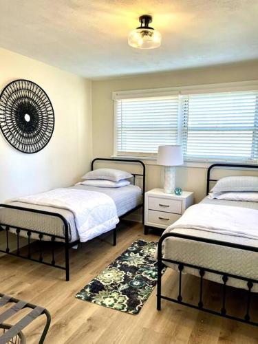 a bedroom with two beds and a rug at Cedar Street Retreat - Heart of Aksarben! in Omaha