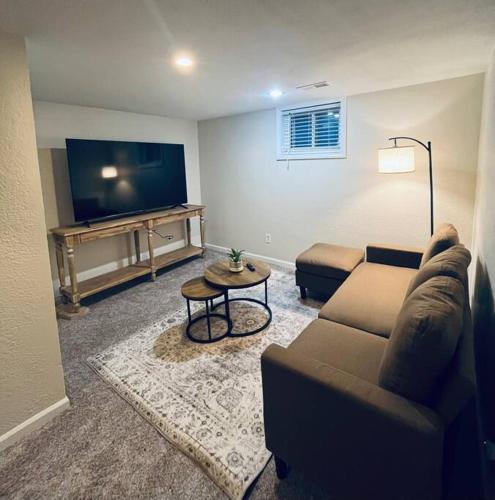 a living room with a couch and a flat screen tv at Cedar Street Retreat - Heart of Aksarben! in Omaha