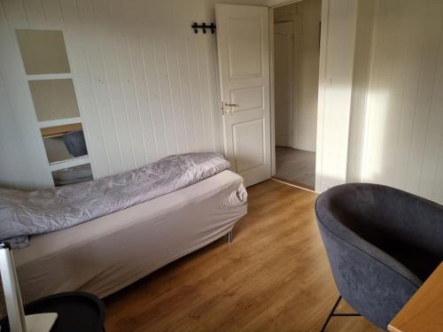 a room with a bed and a chair in it at 1 etasje Jutulveien 6 in Tønsberg
