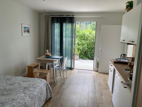 une chambre avec un lit et une table et une cuisine dans l'établissement Nid douillet sous les pins, à Seignosse