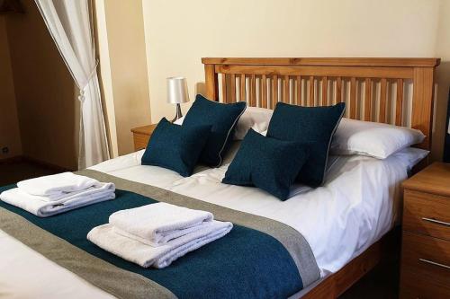 a bed with blue and white pillows and towels on it at Findhorn Bay - Sandpiper Eco chalet in Findhorn