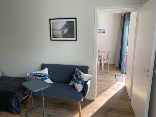 un salon avec un canapé bleu et une table dans l'établissement Nid douillet sous les pins, à Seignosse