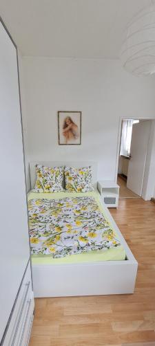 1 cama en un dormitorio blanco con una pared blanca en Ferienwohnung am Althanshof, en Bendorf