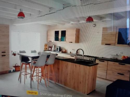 - une cuisine avec un évier et une table avec des tabourets de bar dans l'établissement Chambre à la campagne, à Saint-Hilaire-le-Vouhis