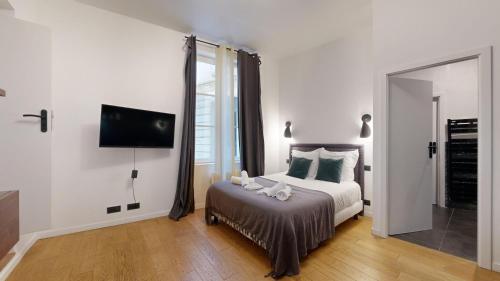 une chambre blanche avec un lit et un miroir dans l'établissement Bluestay 9 - Charmant appartement à Paris 11, à Paris
