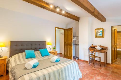 a bedroom with a large bed with blue pillows at Villa La Bergerie by Villa Plus in Saint-Cézaire-sur-Siagne