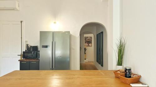 a kitchen with a stainless steel refrigerator in a room at Grand Cosy Family Stay - Centre historique Avignon in Avignon