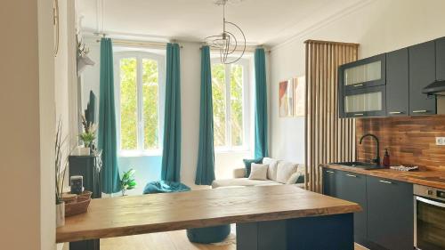 a kitchen with blue cabinets and a table in a room at Grand Cosy Family Stay - Centre historique Avignon in Avignon