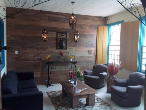uma sala de estar com sofás e uma parede de madeira em Pousada Coração Inconfidente em Tiradentes
