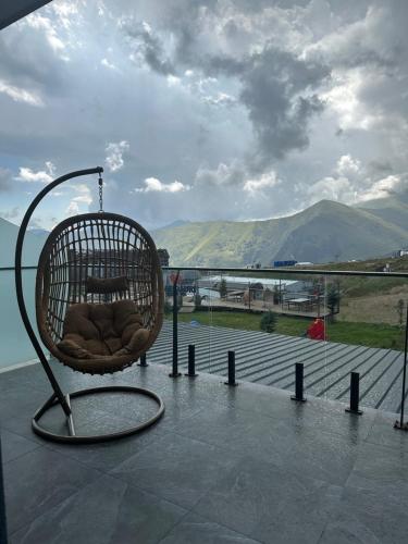 a rattan chair sitting on top of a balcony at Atrium New Gudauri in Gudauri