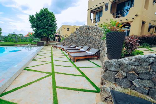 a row of benches next to a building with a pool at The Maridadi Hotel in Moshi