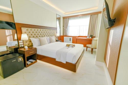a hotel room with a bed and a television at Monaco Hotel in Taytay
