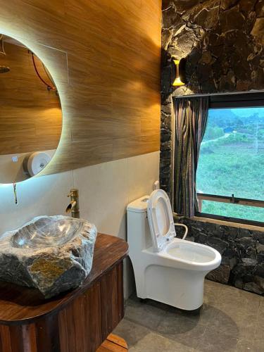 a bathroom with a toilet and a window at Muong Tra Stream Homestay in Làng Cac