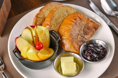 a plate of food with bread and fruit on it at Monaco Hotel in Taytay