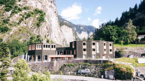 a building on a hill next to a mountain at Story Thusis in Thusis