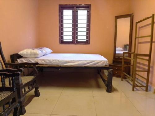 a bed in a room with a mirror and a window at Kit Cott Resort and Retreat in Teligama