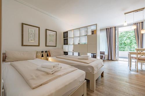 a hotel room with two beds and a dining room at fewo1846 Intermar - Gruene Insel - Studioapartment mit Balkon und Blick ins Grüne in Glücksburg
