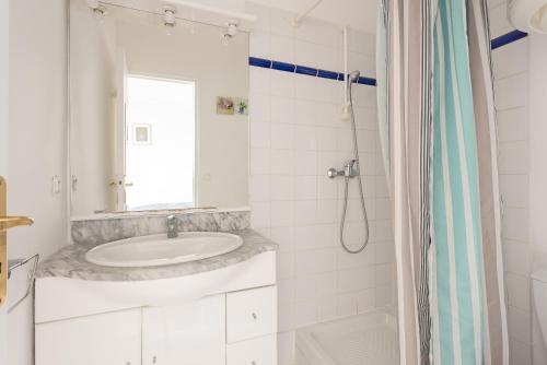 une salle de bain blanche avec un lavabo et une douche dans l'établissement Aurore - Studio 14, à Carcassonne