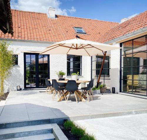 a patio with a table and an umbrella at Vakantiehuis Zand7 in Lommel
